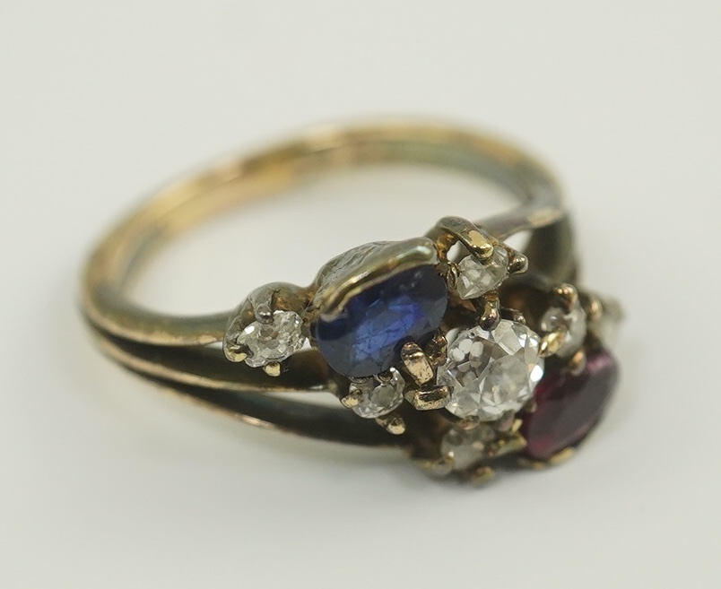 An early 20th century style gold, ruby, sapphire and diamond cluster set triple shank ring